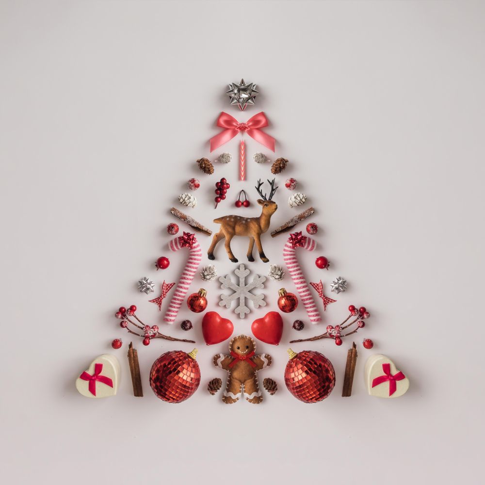 Christmas tree made of Christmas decorations on light background