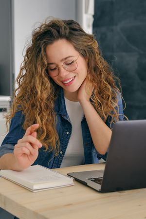 Cheerful businesswoman working on laptop at home