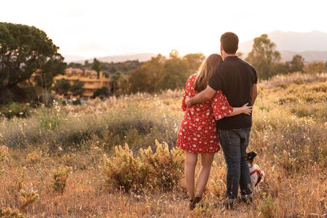 Happy couple with friendly cute dog outdoors
