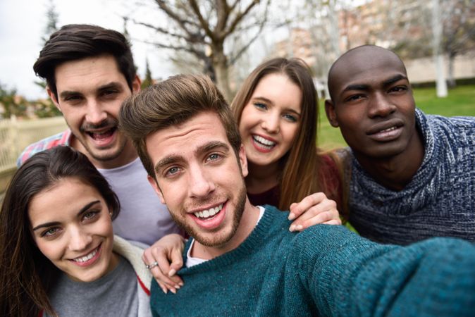 Group of friends looking down at camera and posing