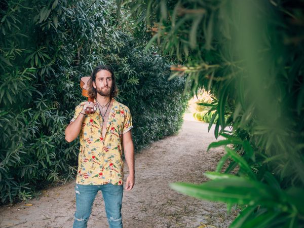 Hipster man in jungle with ukulele