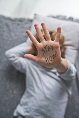 Boy with Stay Home written on palm