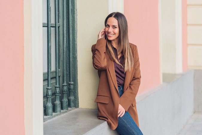 Pleased female in stylish outfit on street smiling away