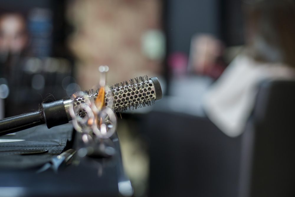 Barber’s scissors and ceramic curler brush with selective focus