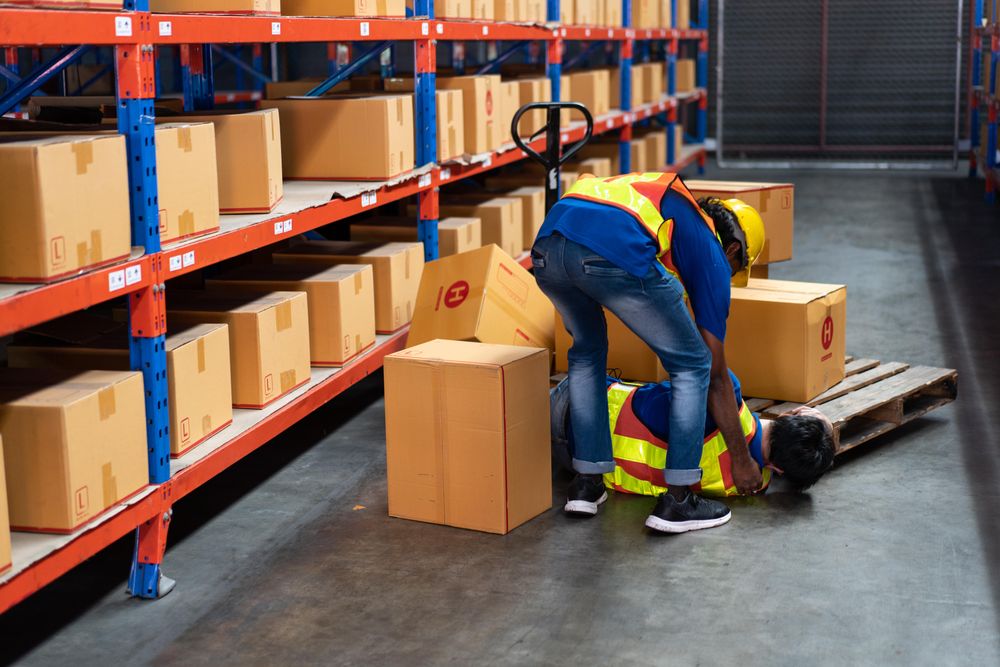 Fallen man helped up by colleague in distribution center