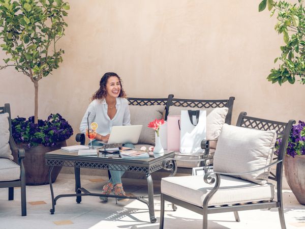 Woman checking email message in laptop and laughing