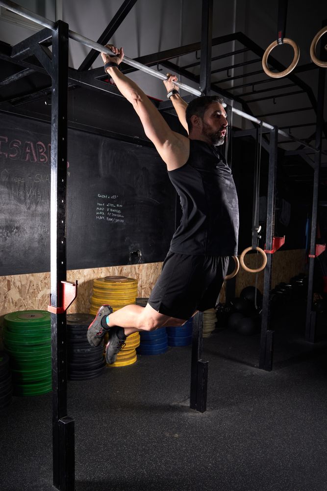 Muscular sportsman exercising on bar