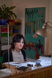 Female jeweler working in workshop with different tools and sket