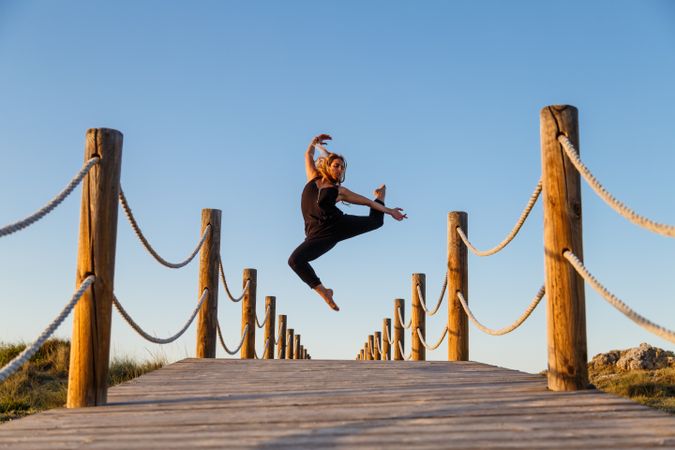 Woman posing in air on footbridge