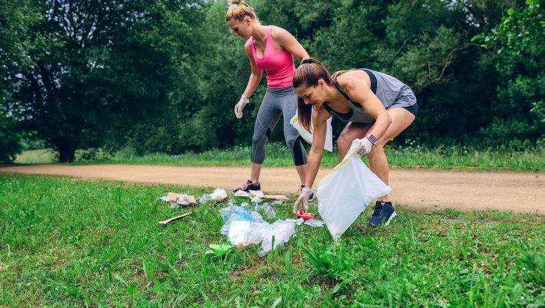 Waste pile and two woman doing plogging