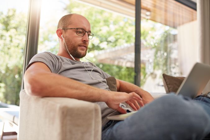 Man using his laptop while relaxing at home