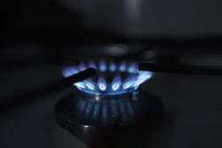 Side view of blue flame on range