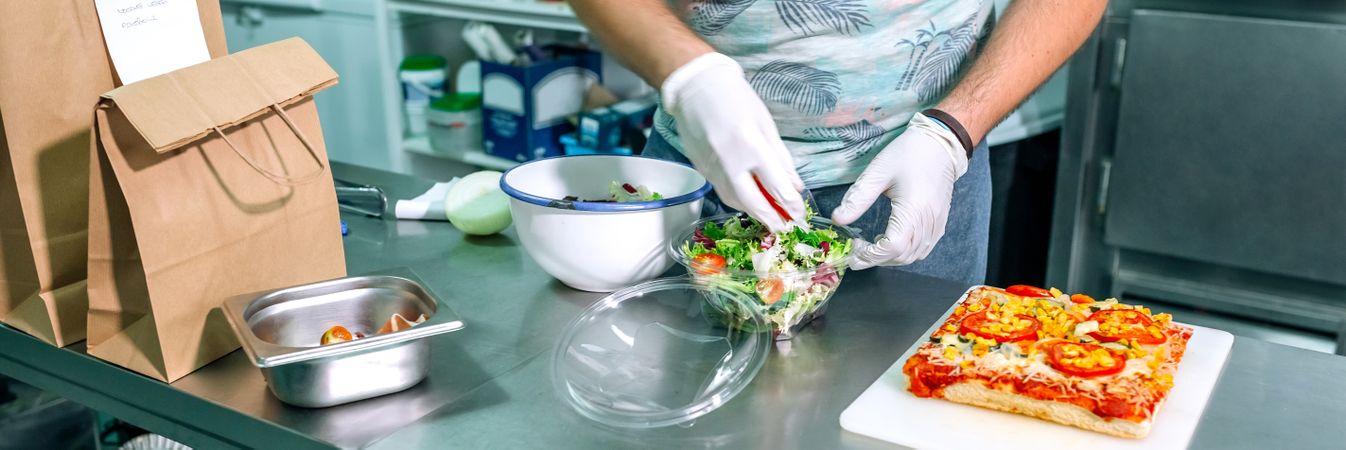 Unrecognizable cook preparing takeaway orders
