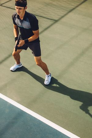 High angle shot of a male tennis player playing tennis on hardcourt