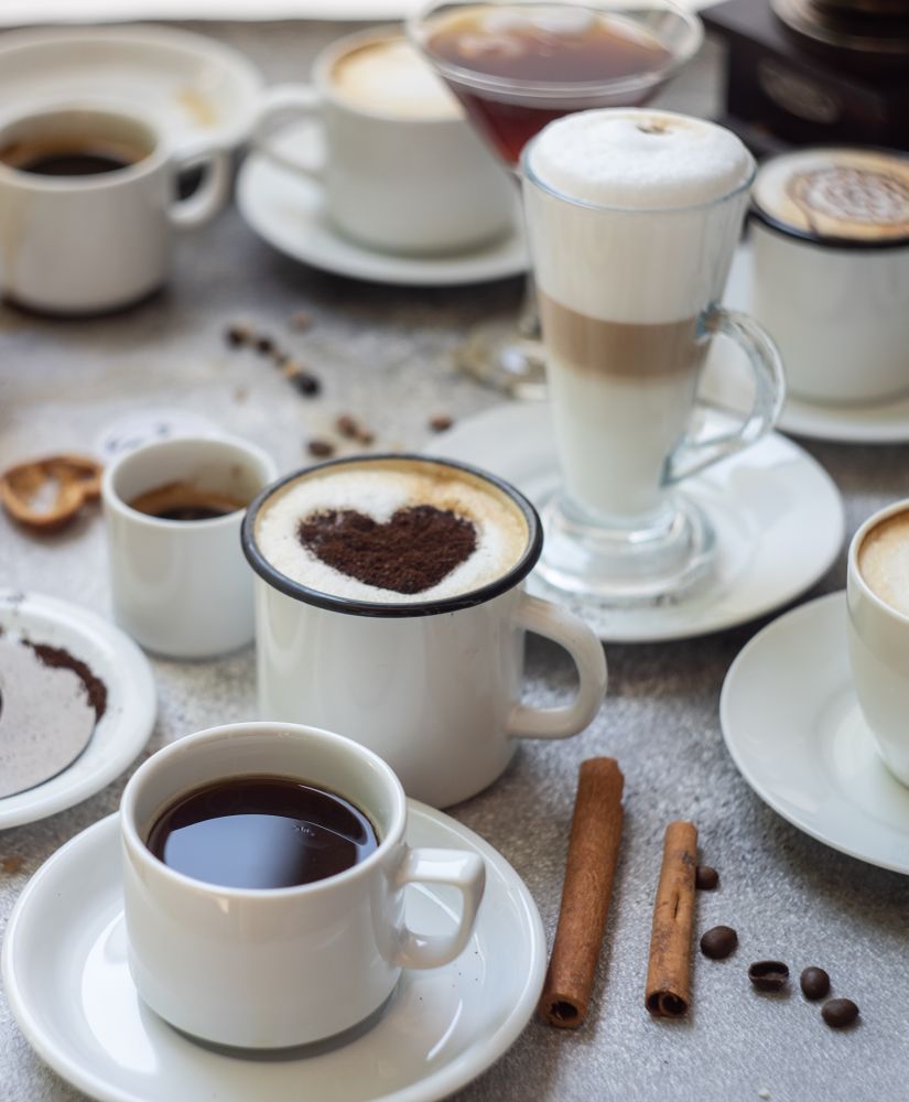Coffee varieties with foam art on stone background