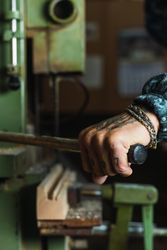 Crop craftsman using wood drilling machine in workshop