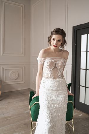 Magnificent pensive young bride in white lace dress looking away and pondering