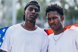 Black men wrapped in American Flag outside
