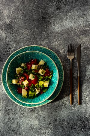 Healthy Greek salad with fresh vegetables, cubed cheese with cutlery