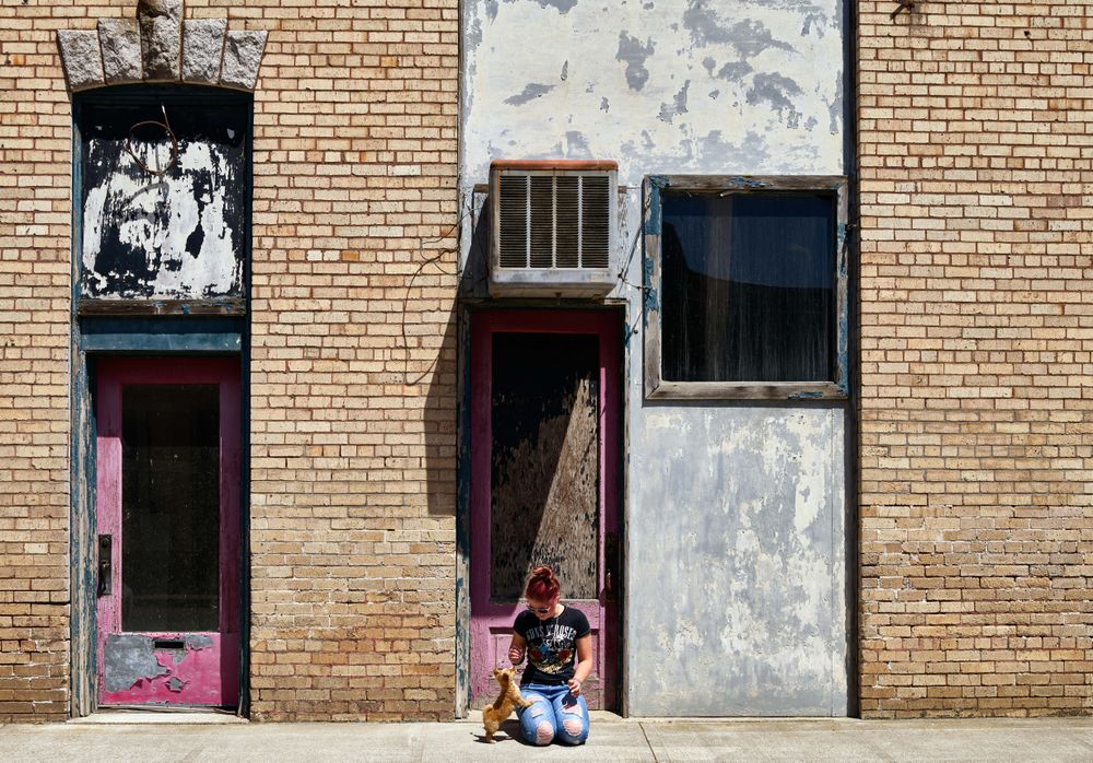 Woman kneeling with small dog on street in Ritzville, Washington