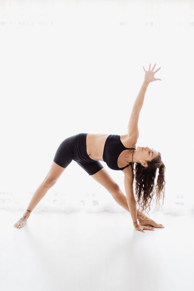 Sportive woman performing yoga pose in room