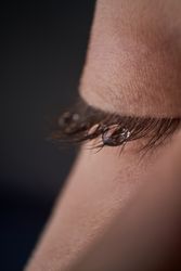 Unrecognizable kid with tear on closed eye