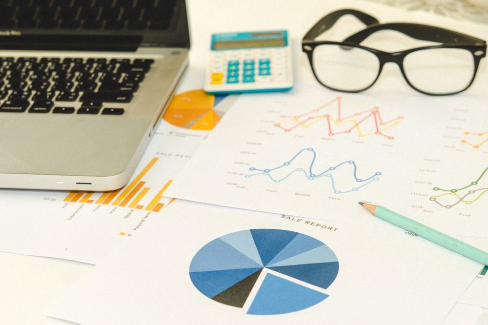 Office Desk with Business Reports, Laptop, Calculator, and Glasses