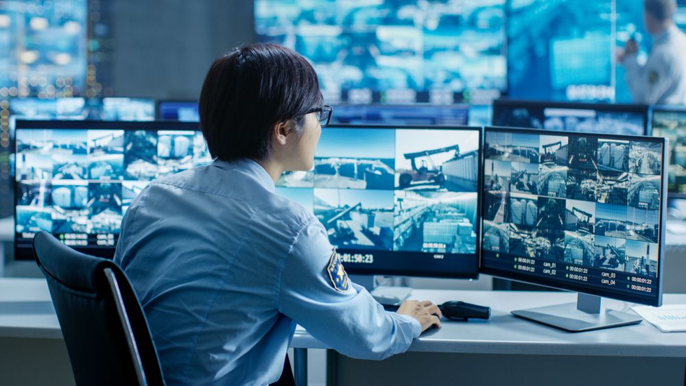 In the Security Control Room Officer Monitors Multiple Screens for Suspicious Activities