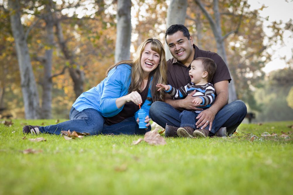 Young Family Playing with Bubbles In The Park