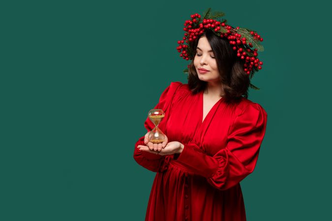 Elegant woman in red dress holding hourglass