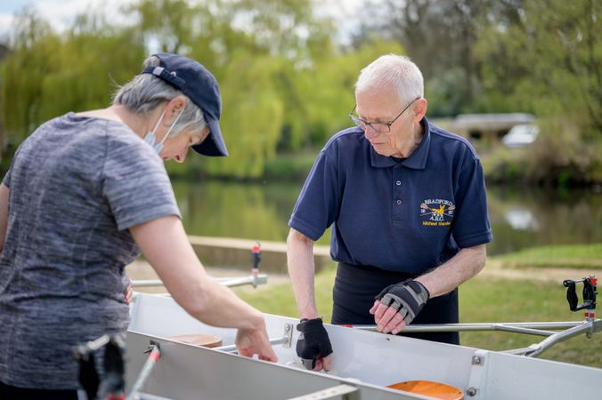 Two older people prepping boat for rowing