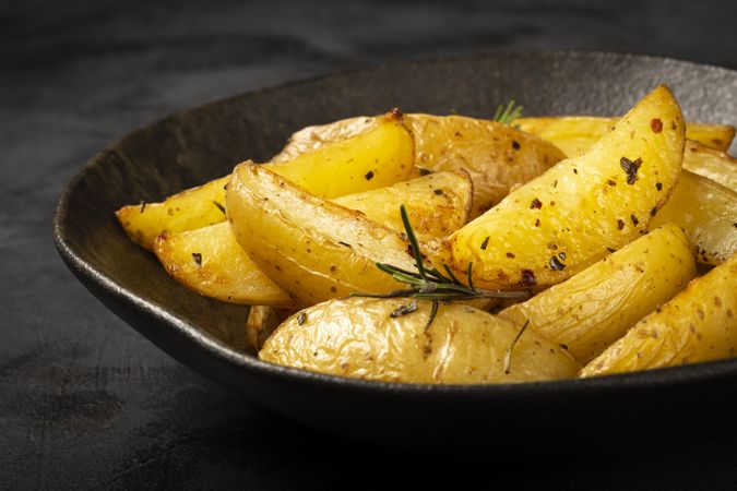 Roasted potatoes with rosemary on the plate.