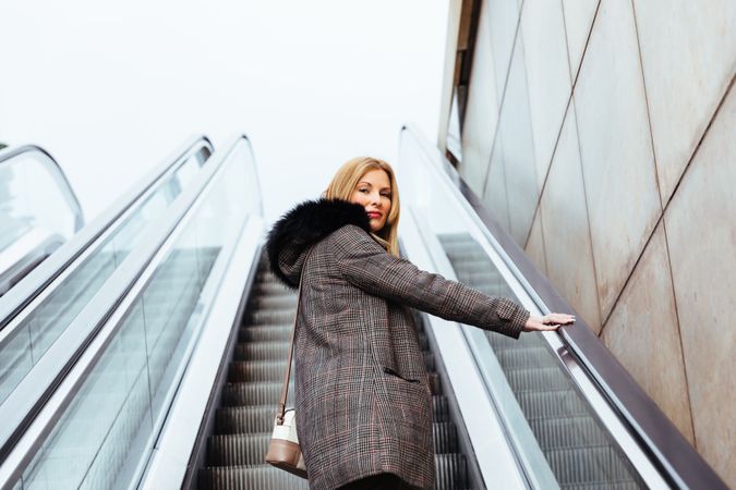 Blonde woman climbing escalators