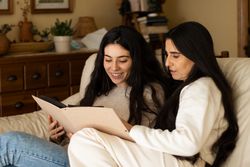 Mature mother and adult daughter watching a photo album