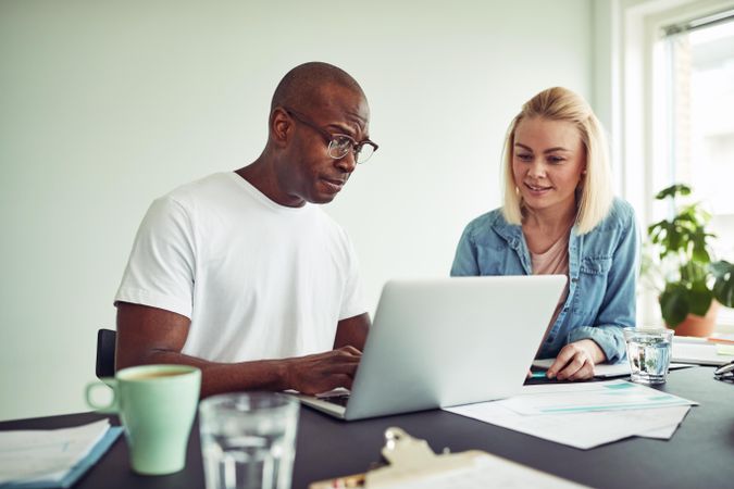 Man and woman working together looking at a laptop