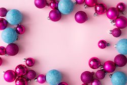 Pink and blue festive baubles bordering pink background