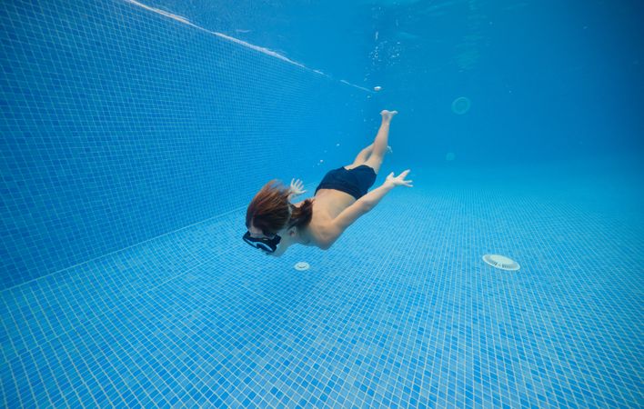 Boy moving in blue swimming pool