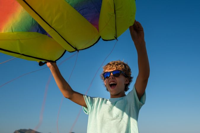 Excited boy with rainbow kite