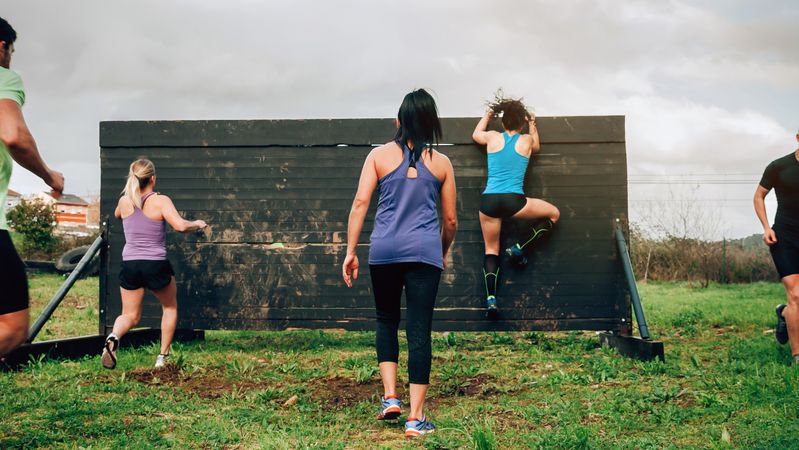 Participants in obstacle course climbing wall