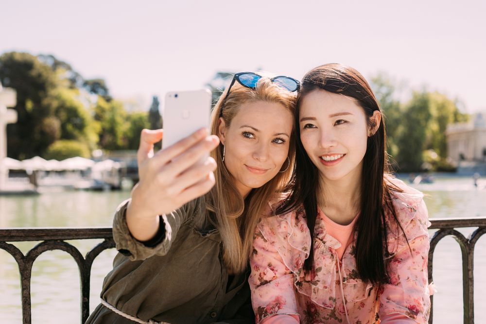 Multiethnic friends taking a selfie photo on embankment