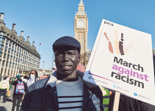 London, England, United Kingdom - March 19 2022: Black man with “March Against Racism” sign
