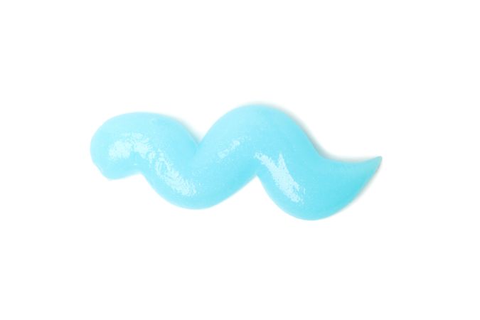 Blue squeezed toothpaste isolated on light background