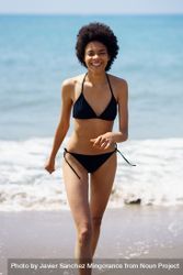 Happy woman walking on shore in bikini 5aVmQ4