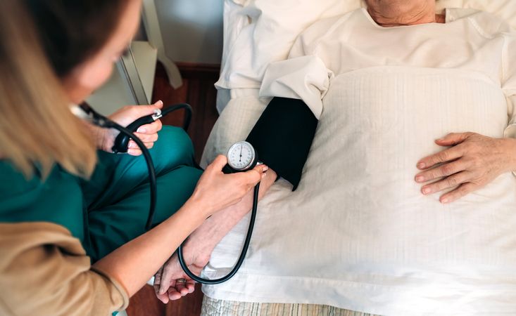 Caregiver checking blood pressure to a woman
