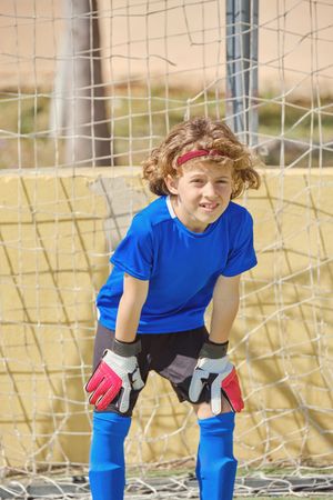 Kid standing at football goal