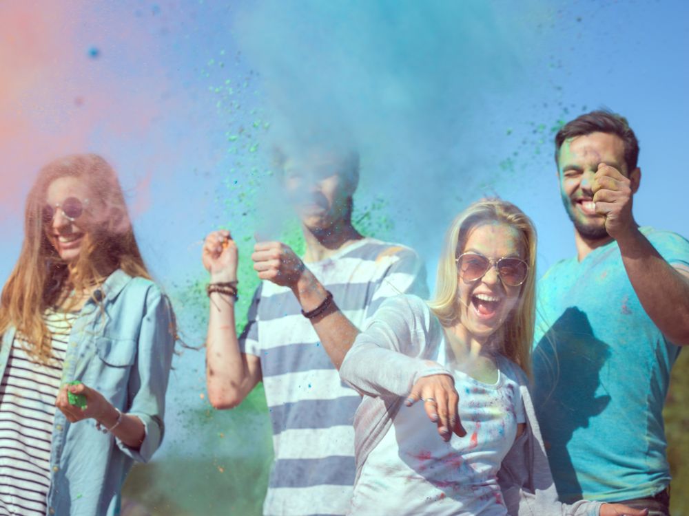 Multi-Ethnic Group of Young People Throw Colorful Powder at Each other in Celebration of Holi Festival.