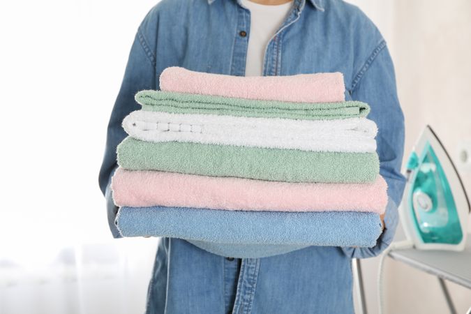Young woman hold clean towels, close up and space for text