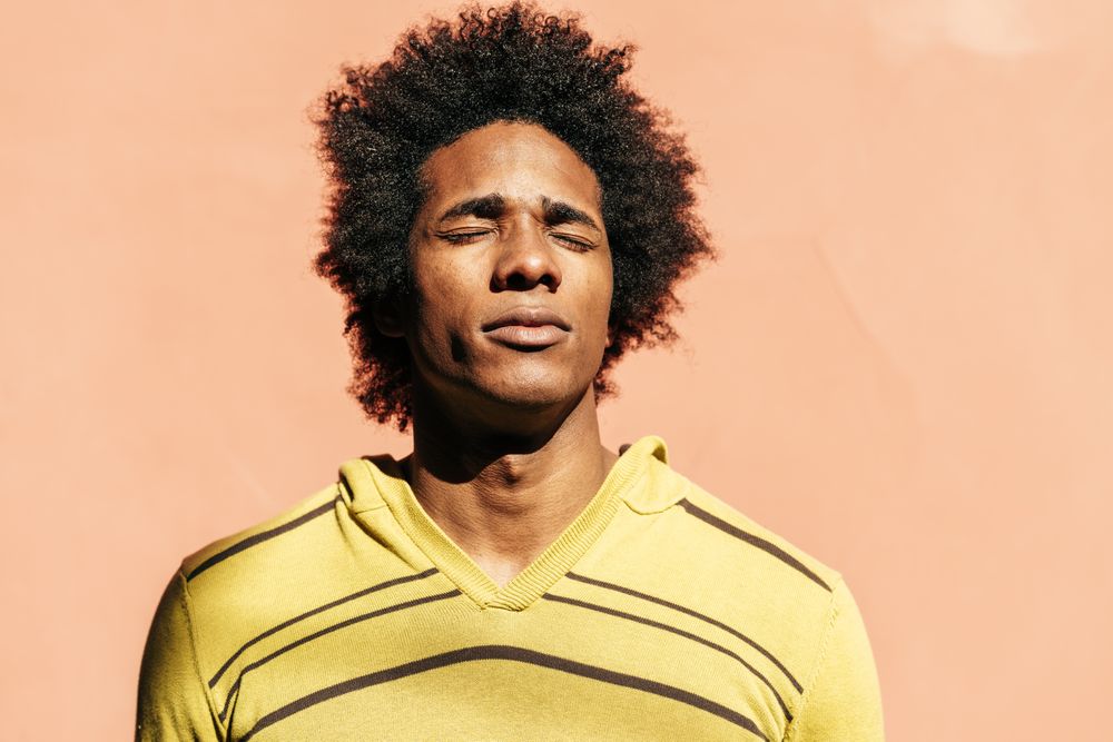 Man facing sun with eyes closed