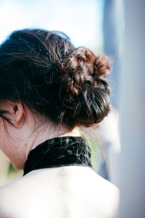 Back side view of back of woman’s neck and loose hair style bun