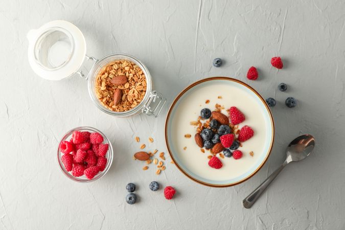 Flat lay composition with parfaits dessert and ingredients on cement background